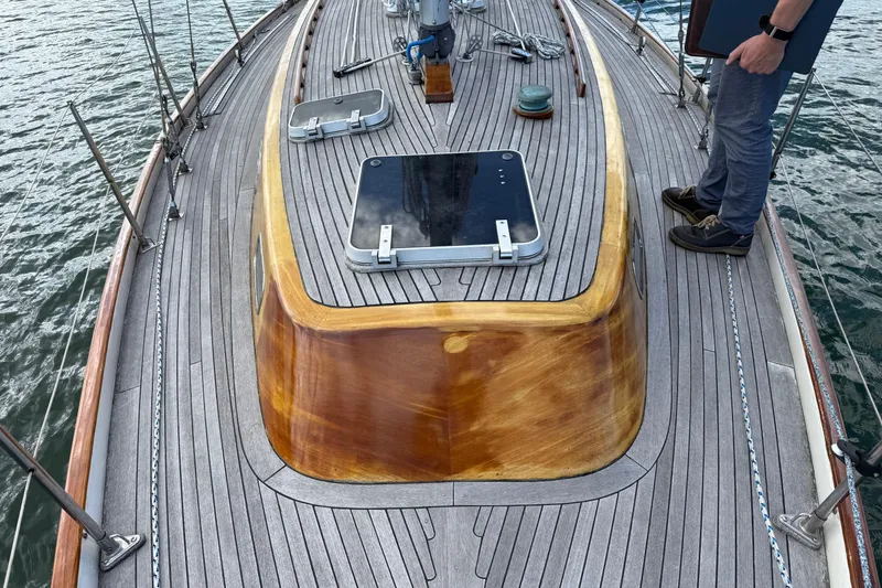 Slide: The Image of Deck of 1986 Vindo 45 sailboat with wooden finish and person standing. - 56
