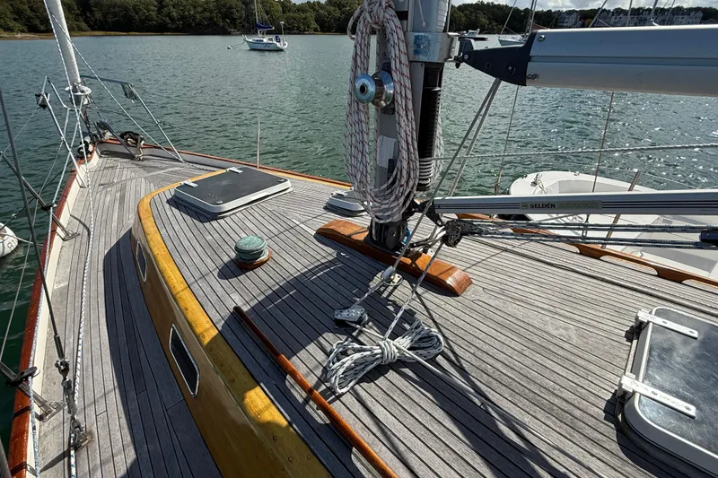 Slide: The Image of Deck of 1986 Vindo 45 sailboat with ropes and hatch, moored on calm water. - 58