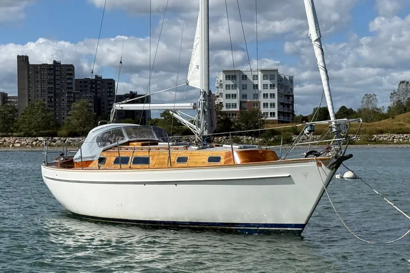 Slide: The Image of Sailboat Vindo 45, 1986 model, anchored in a scenic harbor with buildings in the background. - 7