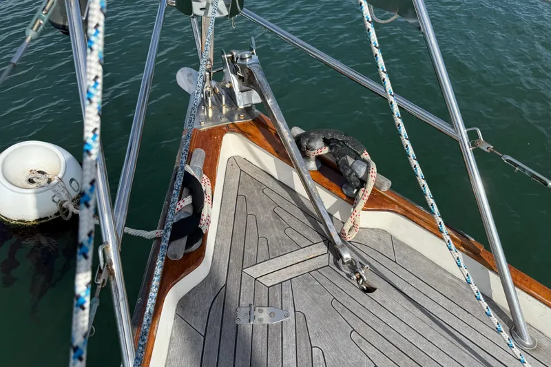 Slide: The Image of Bow of 1986 Vindo 45 sailboat with ropes and anchor in water. - 70
