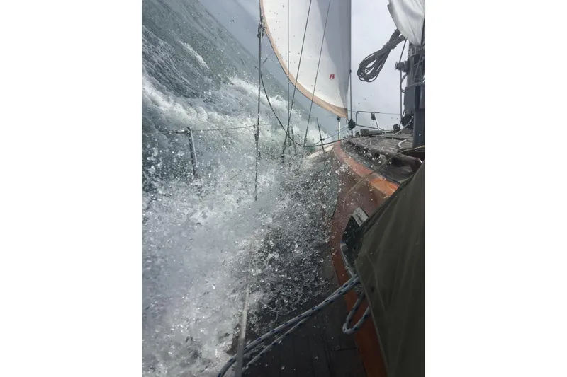 Slide: The Image of Sailing Vindo 45 yacht from 1986 navigating rough seas, water splashing on deck. - 80