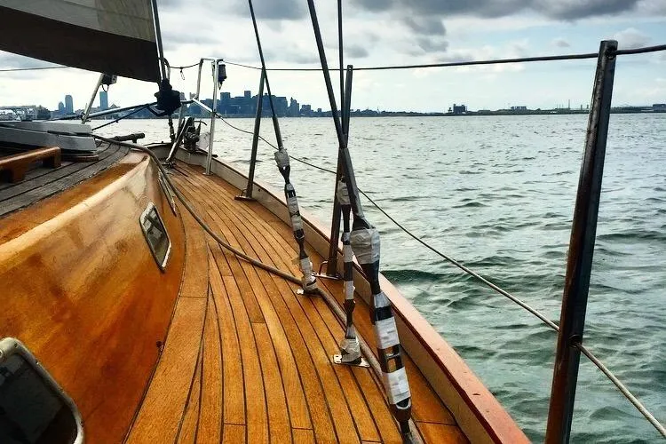 Slide: The Image of Sailing on a 1986 Vindo 45 yacht with a wooden deck, city skyline in the background. - 81
