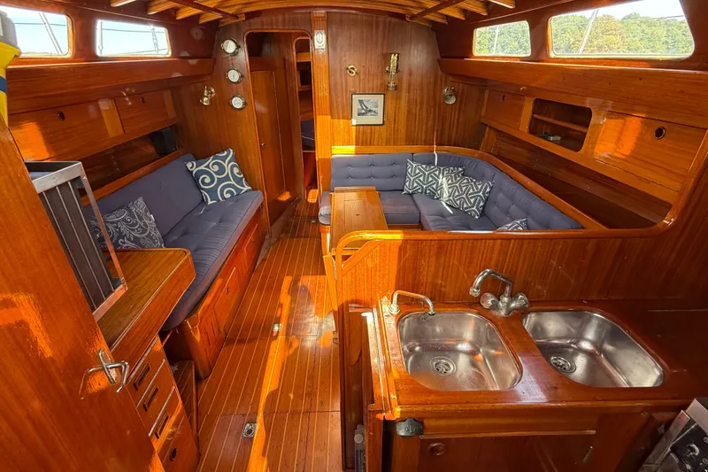 Slide: The Image of Interior of a 1986 Vindo 45 sailboat with wooden finish and cozy seating area. - 9