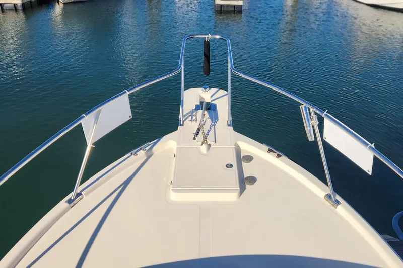 Slide: The Image of Bow view of 2003 Mainship Pilot 30-II boat in calm marina waters. - 10