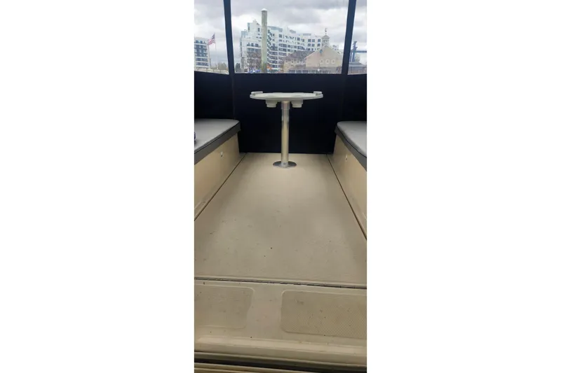 Slide: The Image of 2003 Mainship Pilot 30-II boat interior with seating and table, cityscape view. - 18