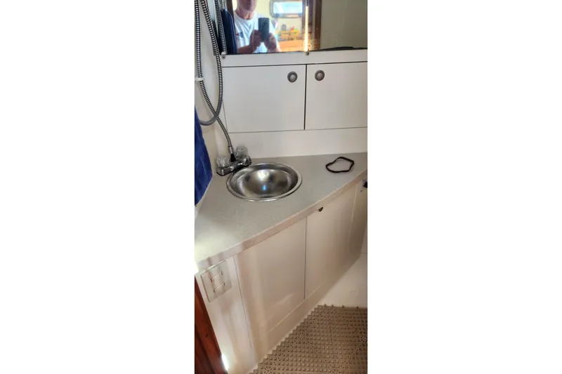 Slide: The Image of 2003 Mainship Pilot 30-II boat bathroom with sink and storage cabinets. - 24