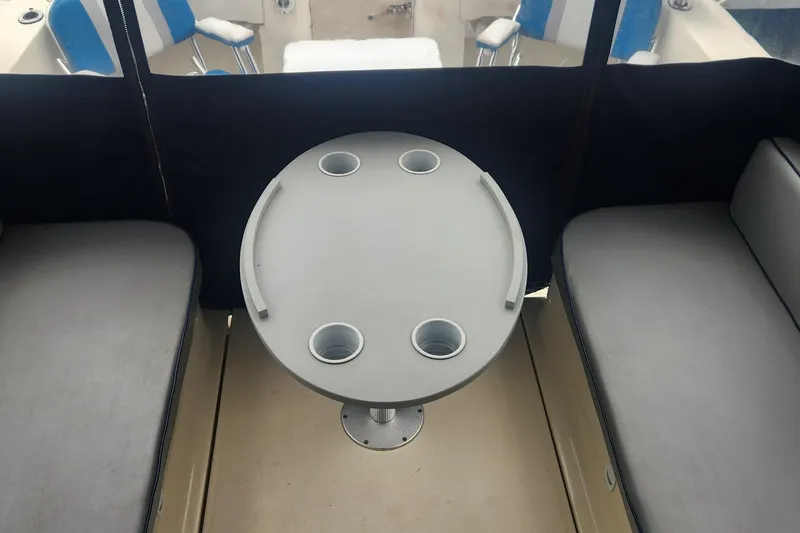 Slide: The Image of 2003 Mainship Pilot 30-II interior with round table and cushioned seating. - 32