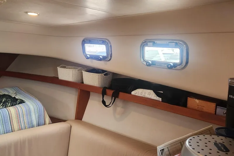 Slide: The Image of Interior of 2003 Mainship Pilot 30-II boat with cozy seating and storage shelves. - 6