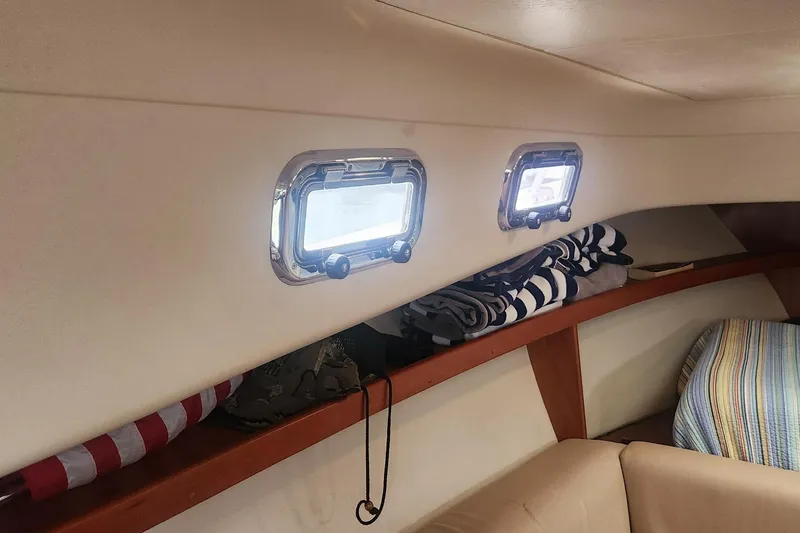 Slide: The Image of Interior of 2003 Mainship Pilot 30-II boat with portholes and neatly stored striped towels. - 8