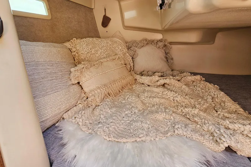 Slide: The Image of Cozy cabin interior of a 1992 Hunter 27 sailboat with textured pillows and blankets. - 16
