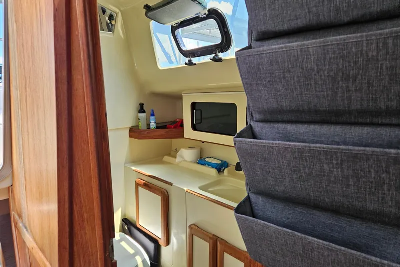 Slide: The Image of Interior of a 1992 Hunter 27 sailboat showing compact kitchen area with storage. - 17