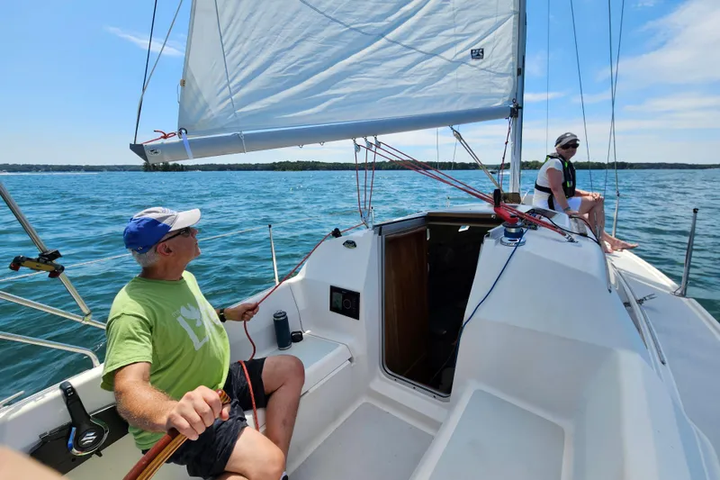 Slide: The Image of Two people sailing on a 1992 Hunter 27 sailboat on a sunny day. - 6