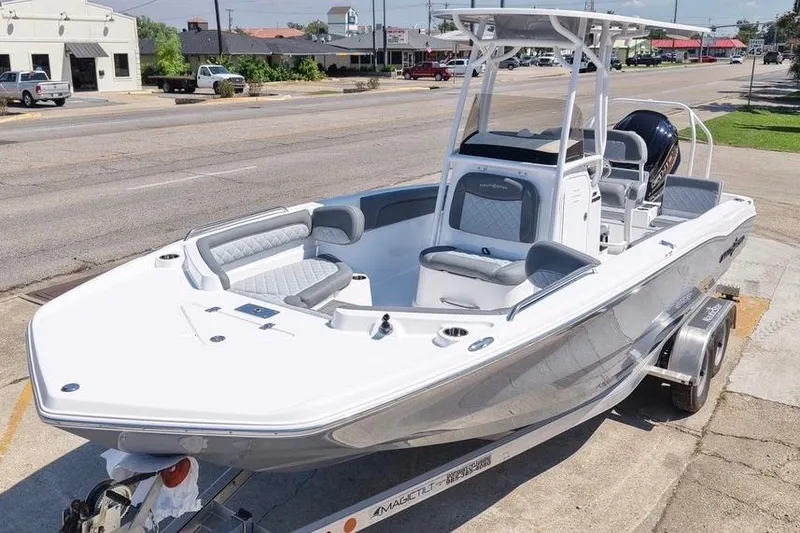 Slide: The Image of 2026 NauticStar 231 Hybrid boat on trailer, parked on urban street. - 3