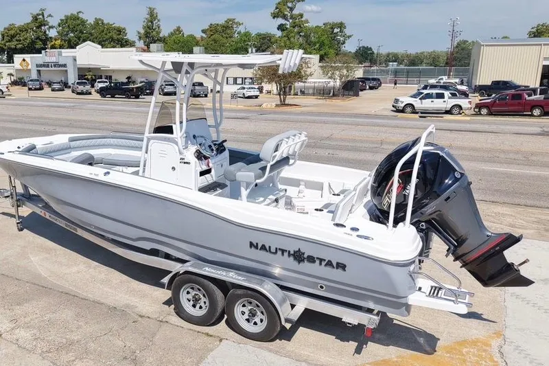 Slide: The Image of 2026 NauticStar 231 Hybrid boat on trailer, parked outdoors. - 6