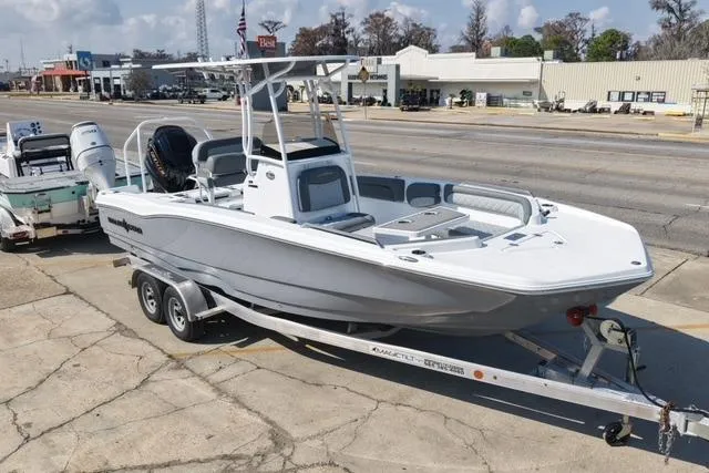 Slide: The Image of 2026 NauticStar 231 Hybrid boat on trailer, parked in urban setting. - 8