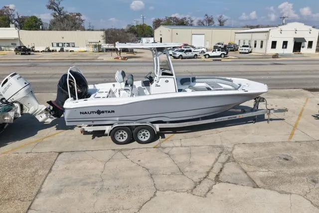 Slide: The Image of 2026 NauticStar 231 Hybrid boat on trailer in industrial area. - 9