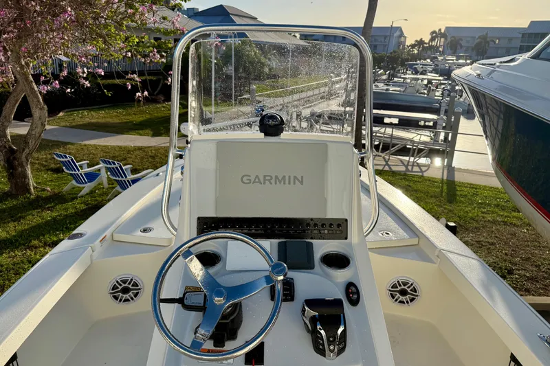 Slide: The Image of 2025 Pathfinder 2300 HPS boat dashboard with Garmin navigation, docked near marina. - 11