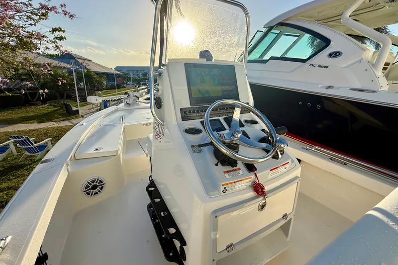 Slide: The Image of 2025 Pathfinder 2300 HPS boat cockpit with steering wheel and control panel in sunlight. - 19