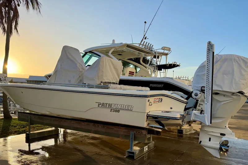 Slide: The Image of 2025 Pathfinder 2300 HPS boat on dock at sunset, covered and ready for use. - 29