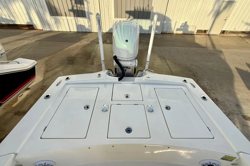 Slide: The Image of 2025 Pathfinder 2300 HPS boat deck with storage compartments and motor, docked outdoors. - 5