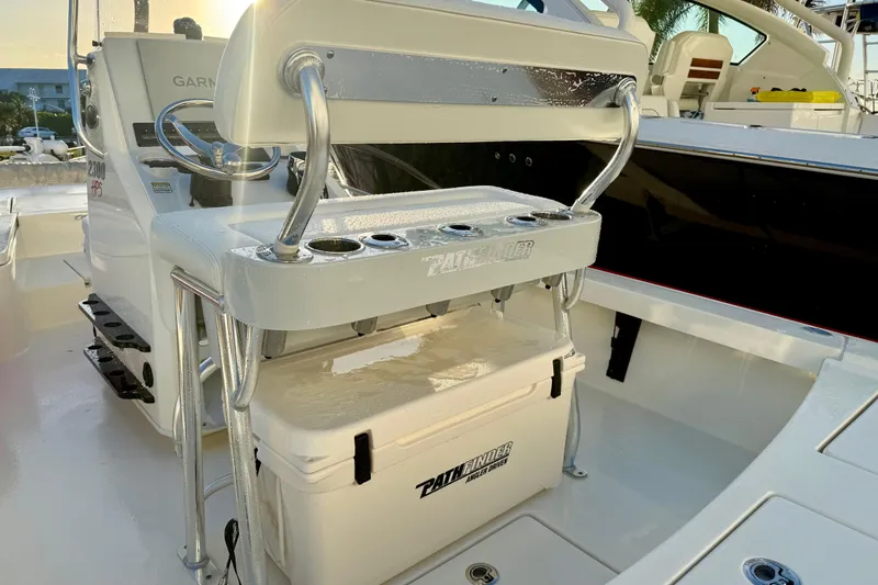 Slide: The Image of 2025 Pathfinder 2300 HPS boat interior with helm, cooler, and seating. - 8