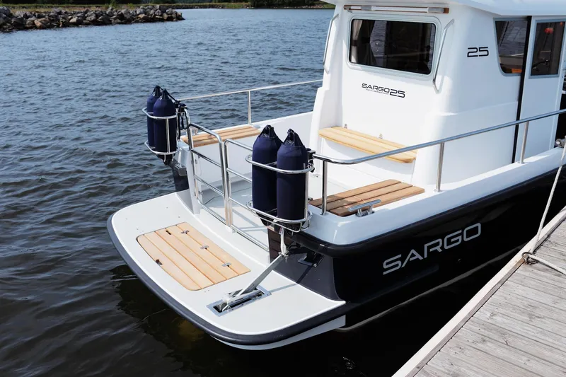 Slide: The Image of 2022 Sargo 25 boat docked, featuring wooden deck and fenders. - 2