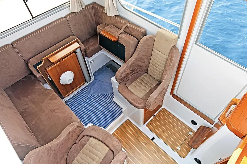 Slide: The Image of Interior of a 2022 Sargo 25 boat with brown upholstery. - 8