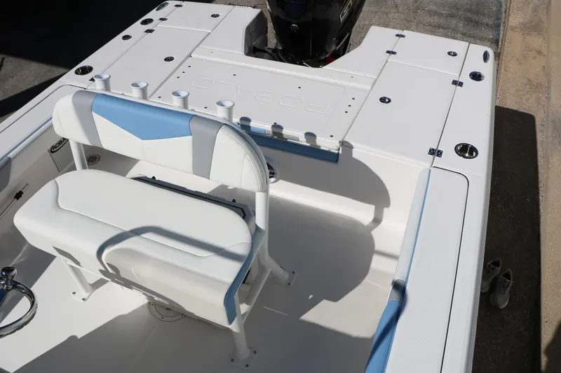 Slide: The Image of 2026 Robalo 226 Cayman boat interior with white and blue seating and rod holders. - 26