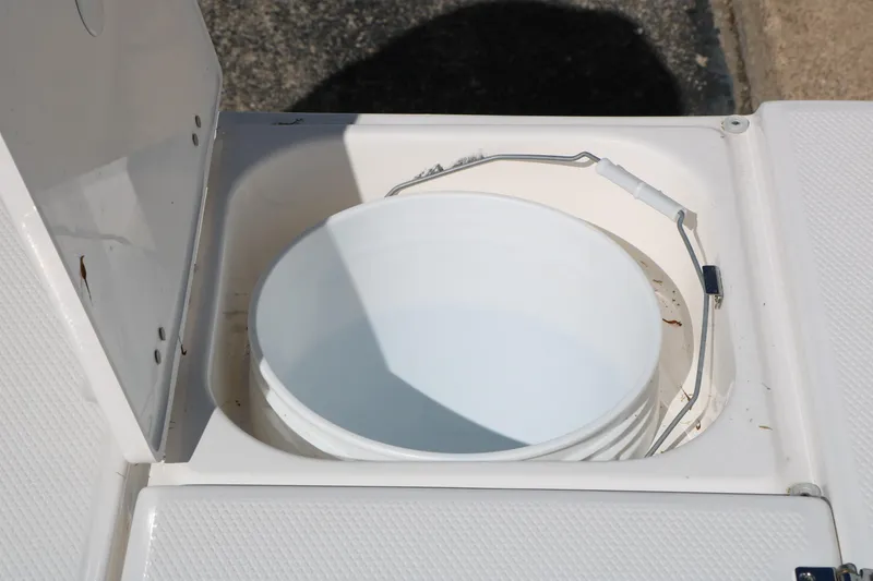 Slide: The Image of Storage compartment with bucket on 2026 Robalo 226 Cayman boat. - 38