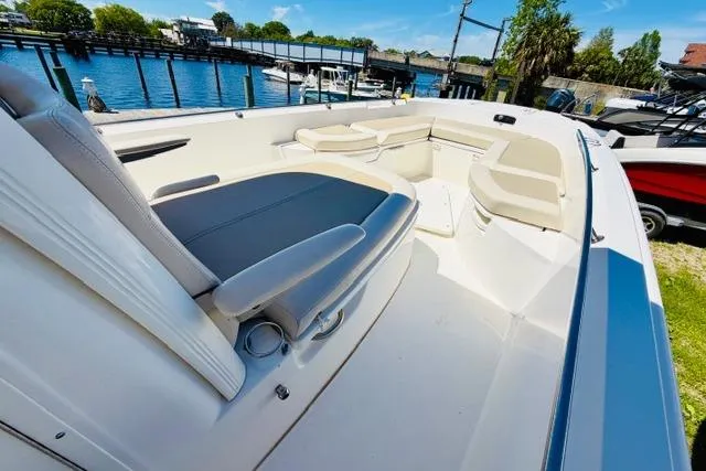 Slide: The Image of 2021 Boston Whaler 270 Dauntless boat interior with seating, docked by the water. - 16