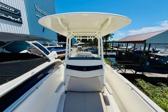 Slide: The Image of 2021 Boston Whaler 270 Dauntless boat docked at a marina under clear blue skies. - 22
