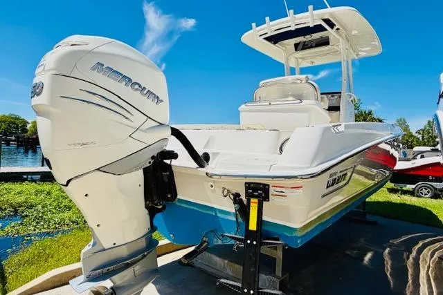 Slide: The Image of 2021 Boston Whaler 270 Dauntless boat with Mercury engine, docked under clear blue sky. - 4