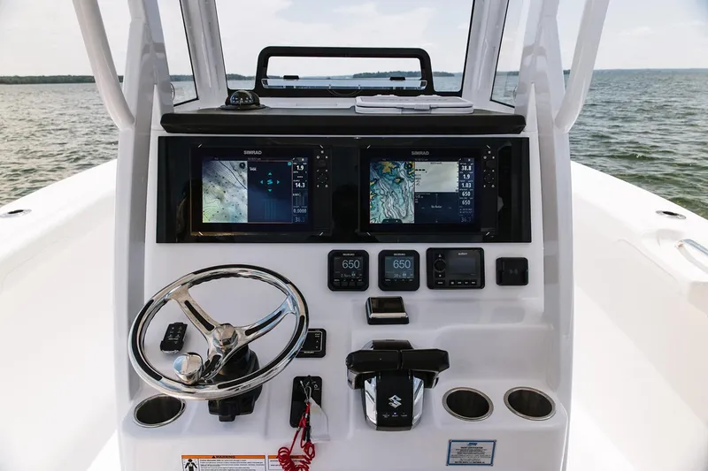 Slide: The Image of Manufacturer Provided Image: 2026 Sea Pro 265FLX Sandbar boat dashboard with navigation screens and steering wheel. - 6