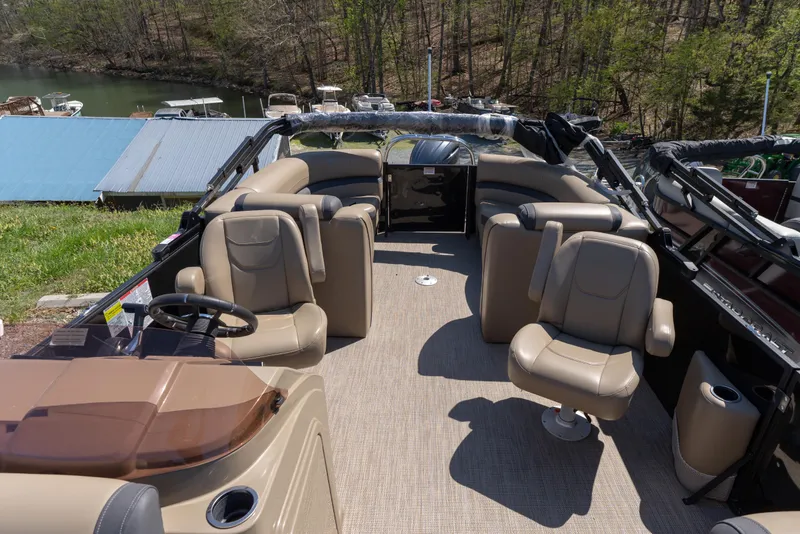 Slide: The Image of 2025 Starcraft EXS 3 pontoon boat interior with beige seating and steering wheel. - 6