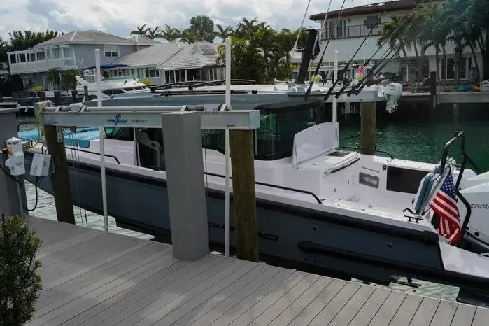 Slide: The Image of 2023 Axopar 37 XC Cross Cabin docked by waterfront homes. - 16