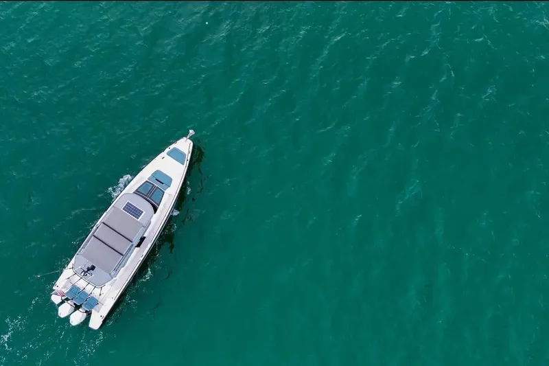 Slide: The Image of Aerial view of 2023 Axopar 37 XC Cross Cabin on turquoise water. - 2