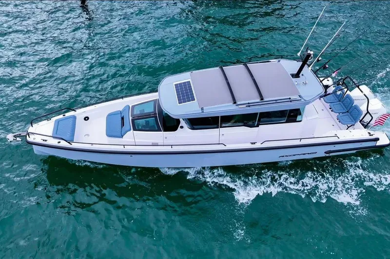 Slide: The Image of 2023 Axopar 37 XC Cross Cabin cruising on turquoise water. - 4