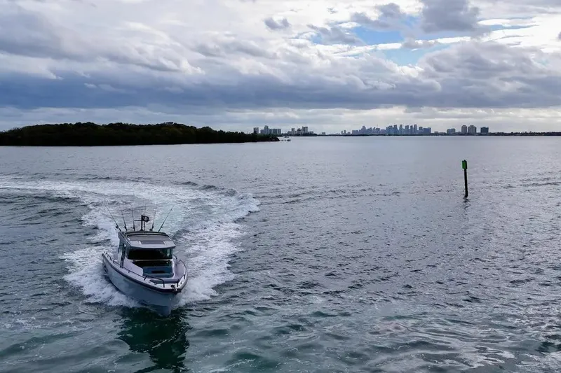 Slide: The Image of 2023 Axopar 37 XC Cross Cabin cruising on open water under cloudy skies. - 5