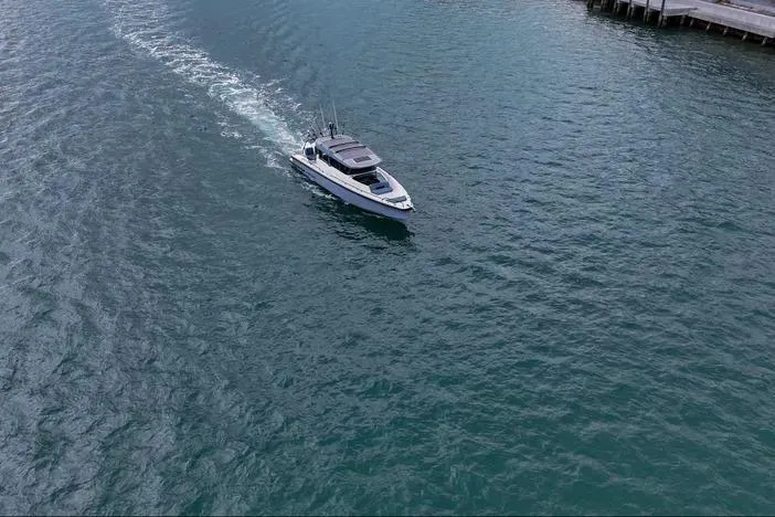 Slide: The Image of 2023 Axopar 37 XC Cross Cabin cruising on open water. - 6