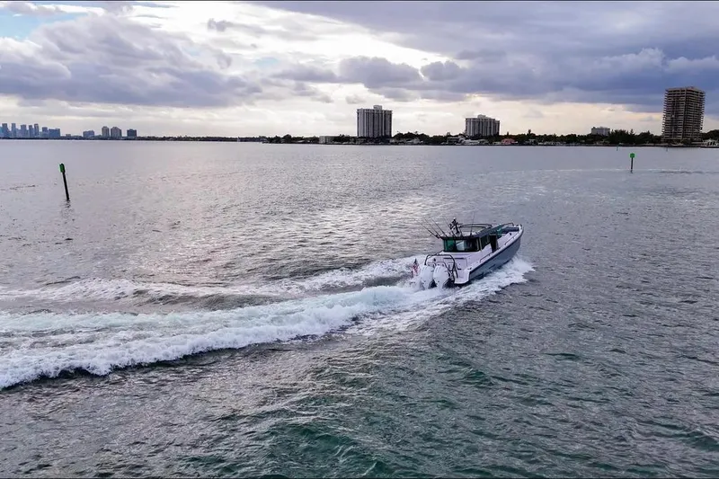 Slide: The Image of 2023 Axopar 37 XC Cross Cabin cruising on a calm, scenic waterway. - 8