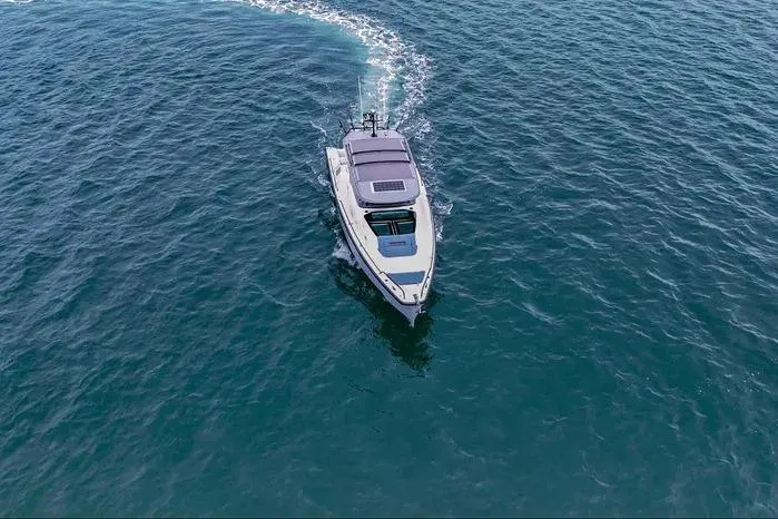 Slide: The Image of 2023 Axopar 37 XC Cross Cabin cruising on open water, aerial view. - 9