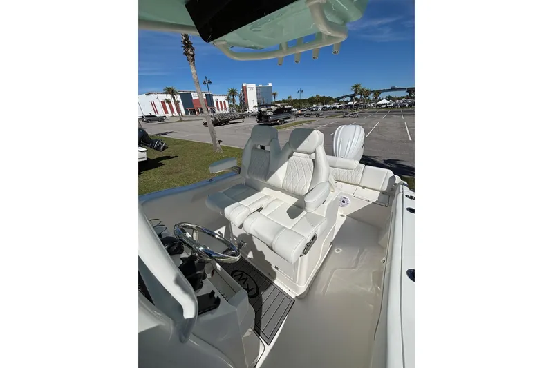 Slide: The Image of 2026 Key West 239 FS boat interior with white seating and steering wheel. - 9