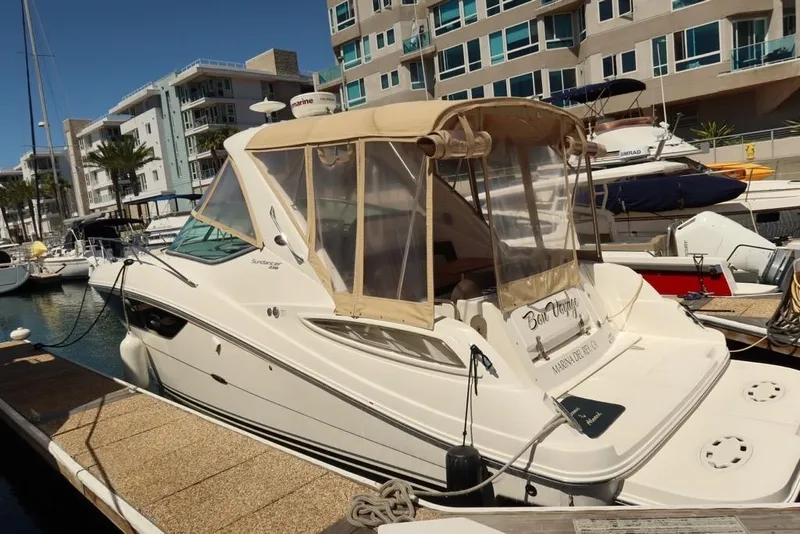 Slide: The Image of 2014 Sea Ray 330 Express Cruiser docked at a marina, surrounded by modern buildings. - 1
