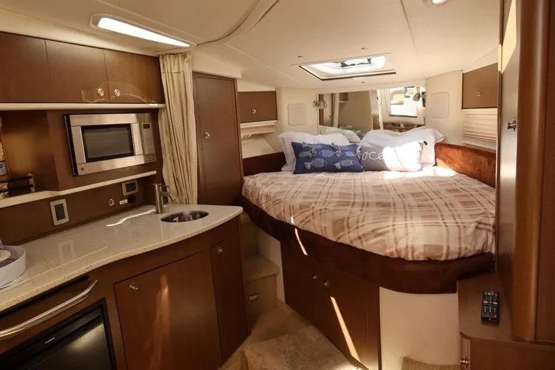 Slide: The Image of Luxurious interior of 2014 Sea Ray 330 Express Cruiser with cozy bed and kitchenette. - 14