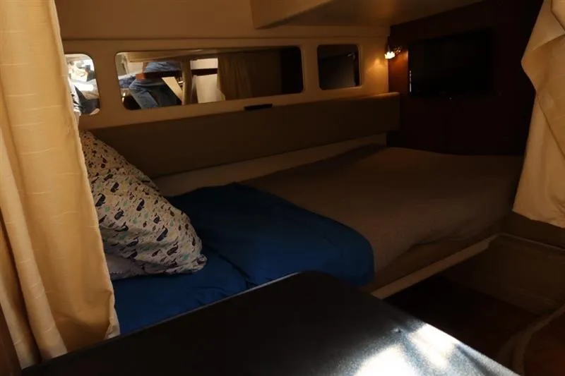 Slide: The Image of Cozy cabin interior of 2014 Sea Ray 330 Express Cruiser with bed and window. - 15