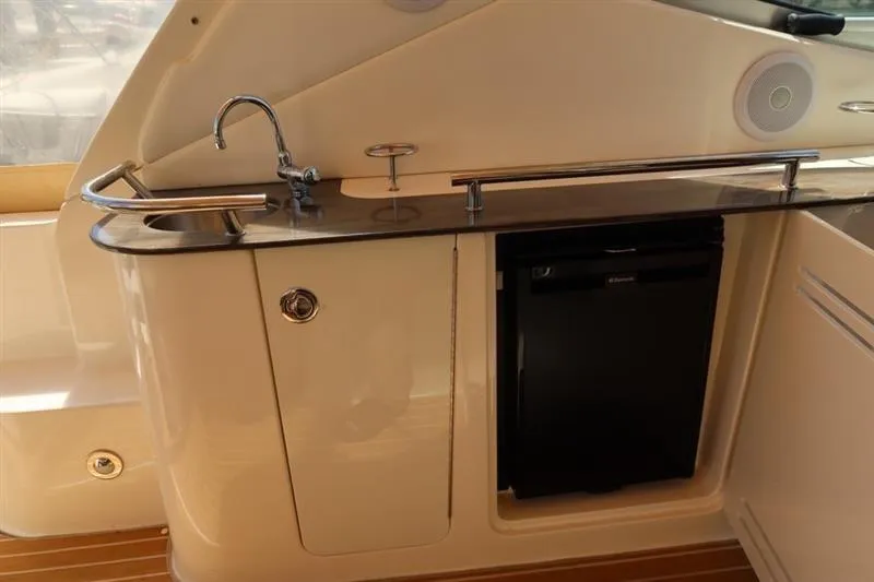 Slide: The Image of 2014 Sea Ray 330 Express Cruiser kitchenette with sink and mini fridge. - 6