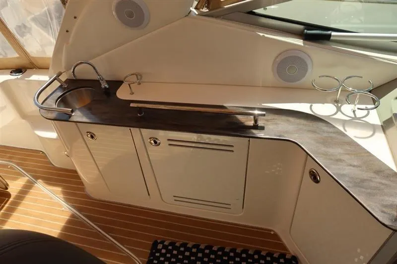 Slide: The Image of 2014 Sea Ray 330 Express Cruiser interior with sleek kitchenette and wood flooring. - 7