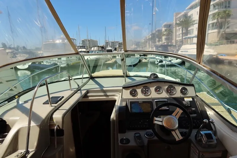 Slide: The Image of 2014 Sea Ray 330 Express Cruiser cockpit with steering wheel and navigation instruments. - 9