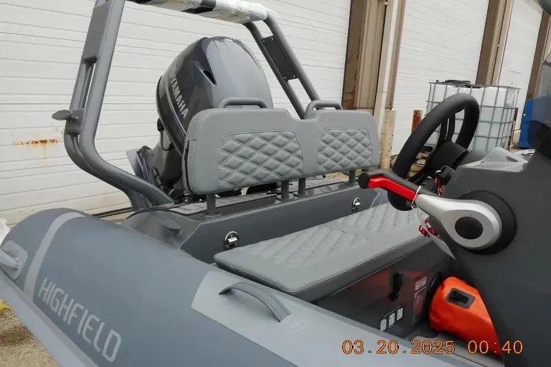 Slide: The Image of 2025 Highfield Sport 390 boat interior with Yamaha engine, featuring gray seating and steering controls. - 5