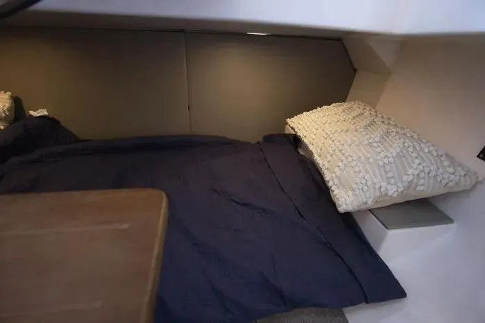 Slide: The Image of Cozy cabin interior of 2026 SeaWell 345XL boat with navy bedding and textured pillow. - 12